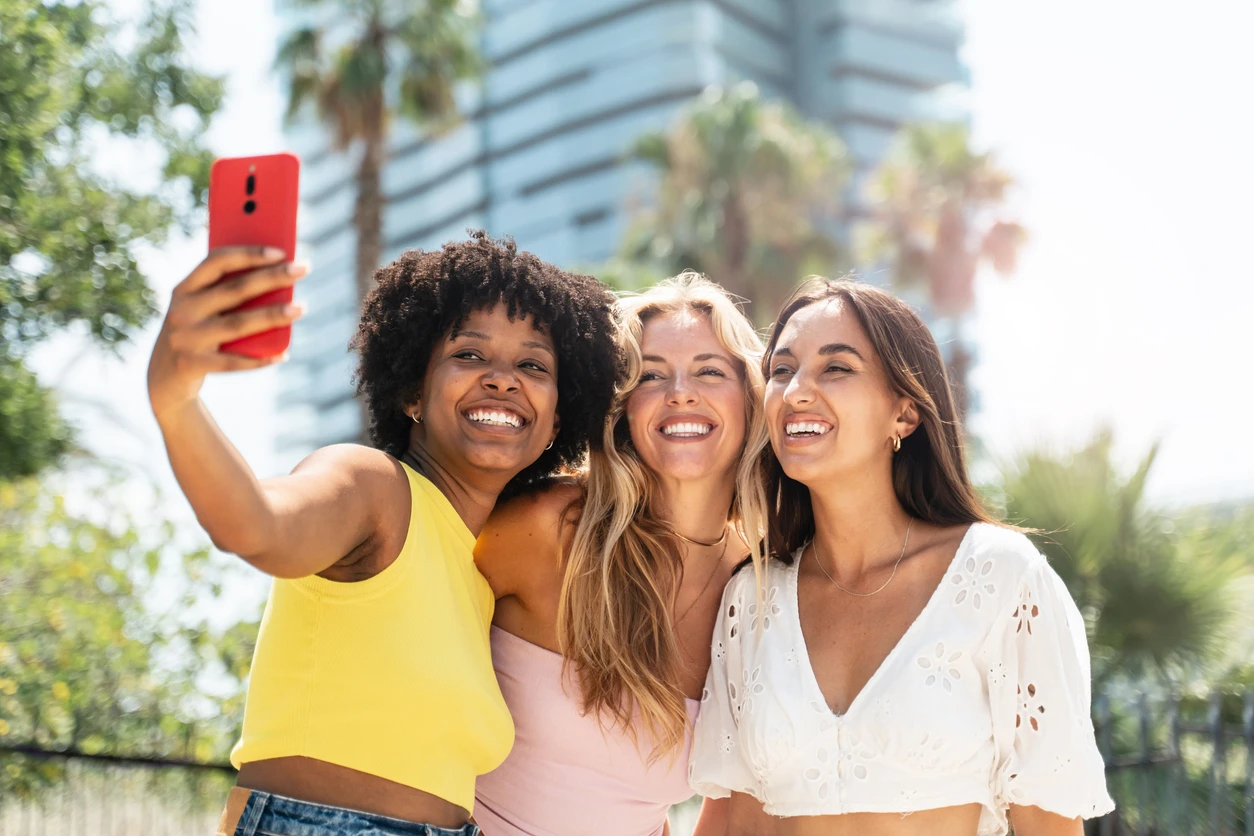Friends taking a sunny selfie together in Hoboken