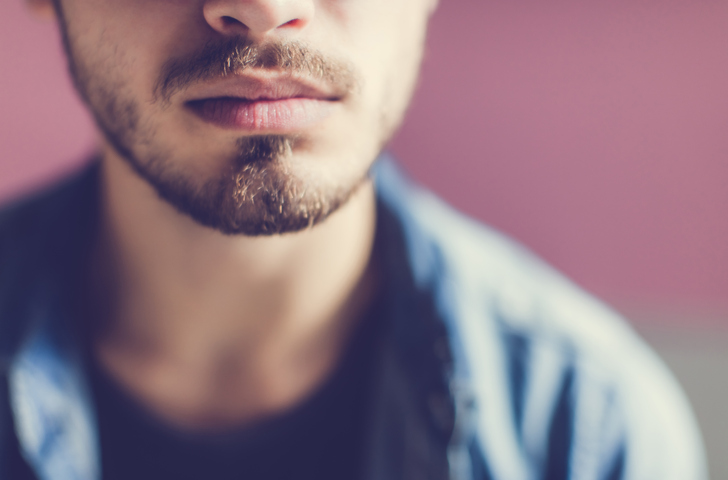 Closeup of a young unshaven man and his lips
